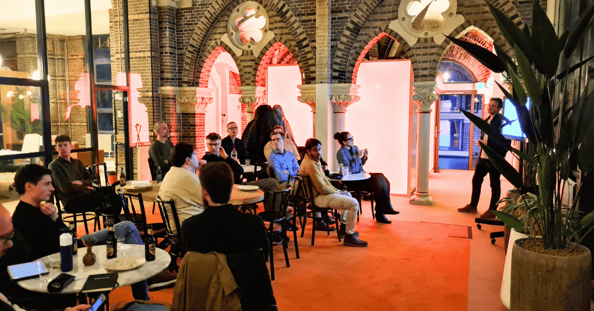 a group of people sitting at tables in a room with arches and red lights